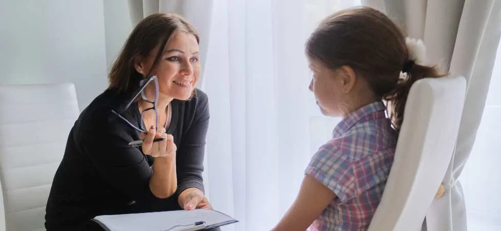 trabajadora social entrevistando a una niña